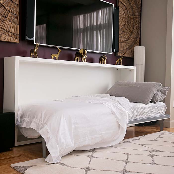 Kali horizontal twin Murphy bed open with bedding, shown in a compact living room setup beneath a mounted TV.