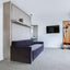 Oslo Sofa Queen Murphy Bed in the closed position with hidden storage in a contemporary hotel room with minimalist decor