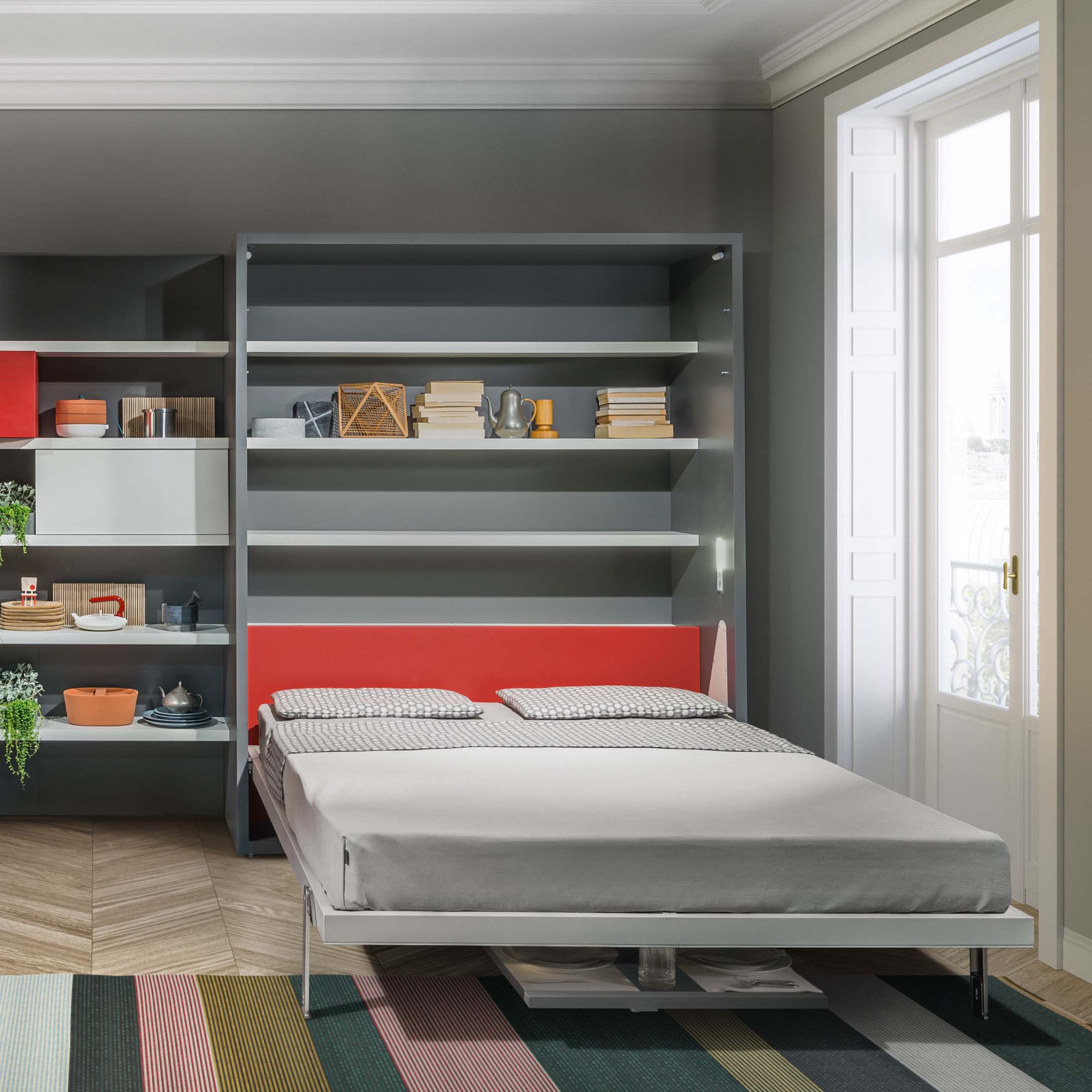 Penelope Dining queen Murphy bed with built-in shelving and red accent back panel, designed for multifunctional and space saving furniture solutions.