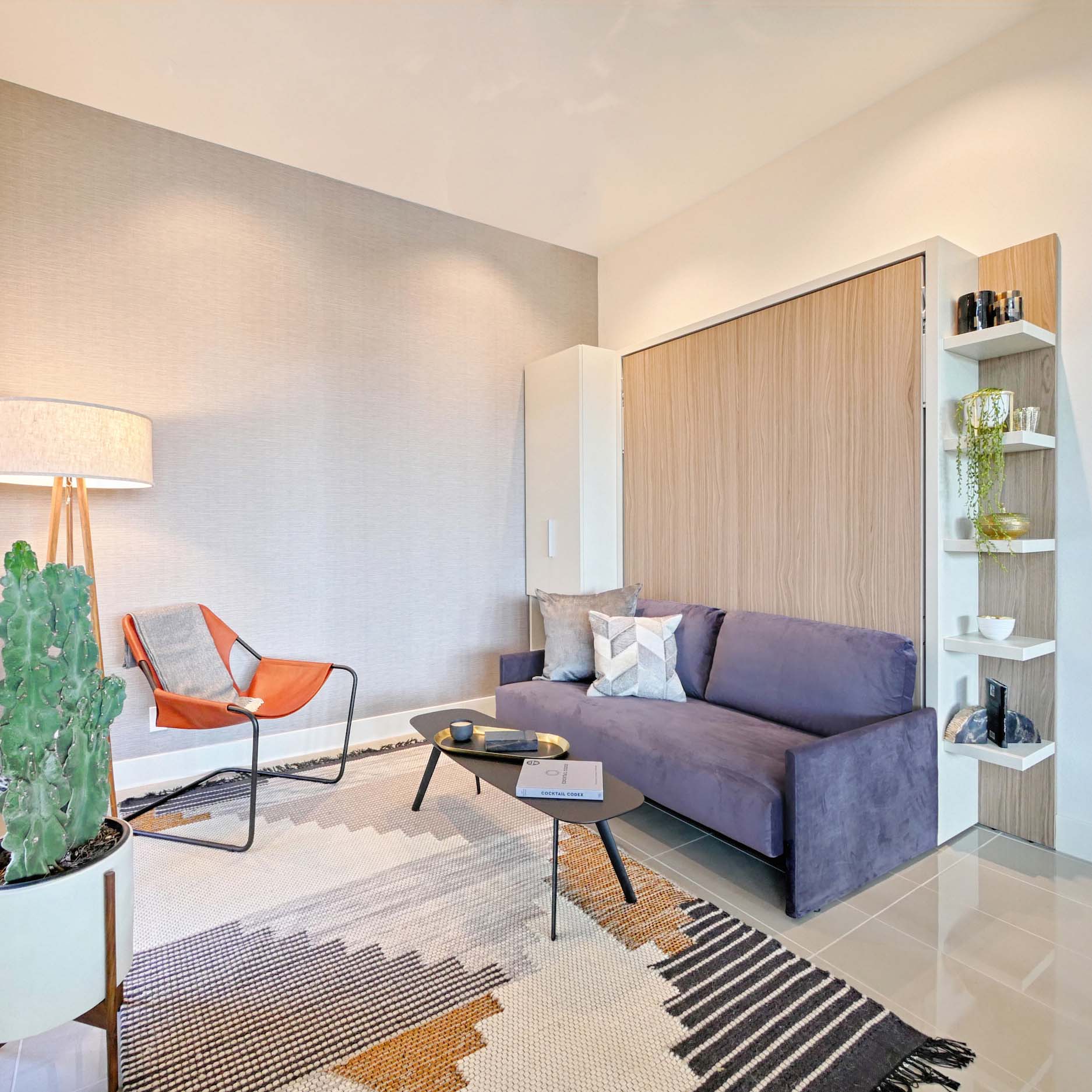 Penelope Sofa Queen Murphy bed closed with deep purple couch and wood panel wall bed in modern living room.